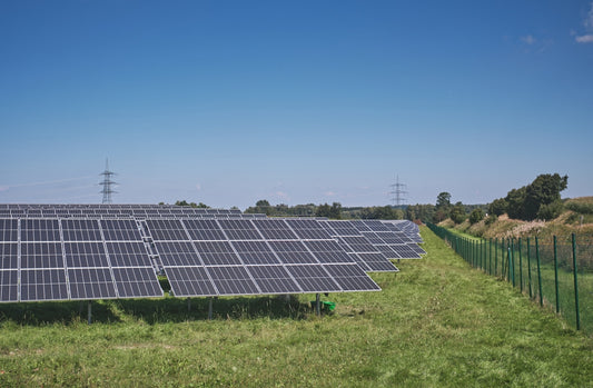 solar panels on green grass field under blue sky during daytime