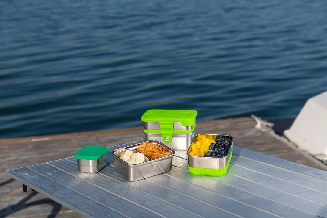 a picnic table with food on it near a body of water