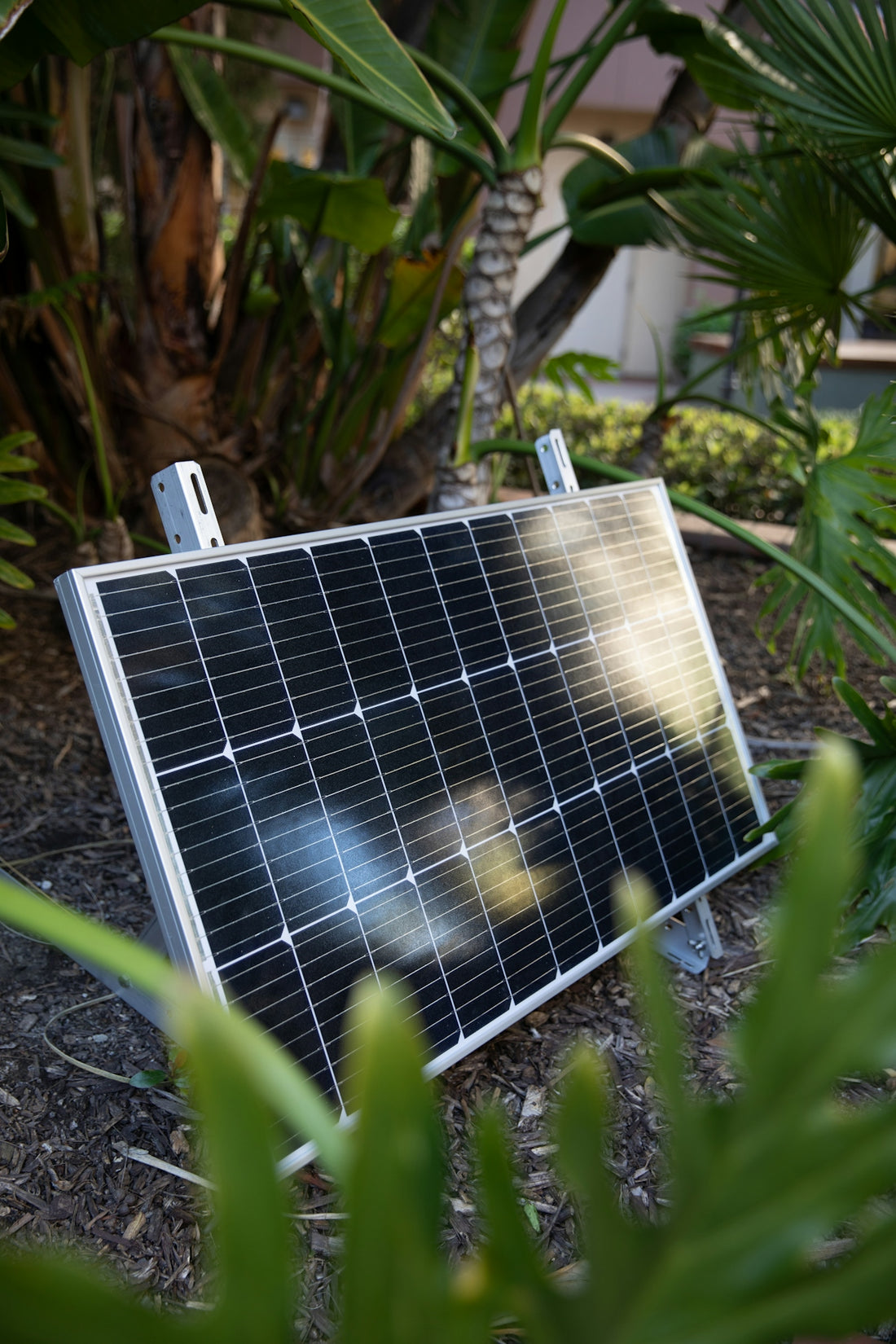 a solar panel laying on the ground in a garden