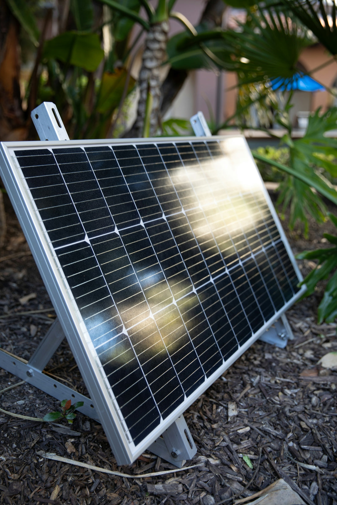 a solar panel sitting on the ground in a garden