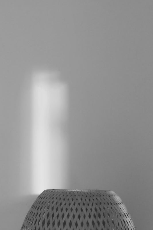 a black and white photo of a light coming through a window