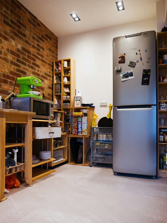 A compact, modern kitchen with a brick wall.